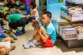 A Chinese young school boy sitting on the floor and reading books at the Shenzhen Central Bookstore in Futian district, Shenzhen,