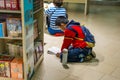 A Chinese young school boy sitting on the floor and reading books at the Shenzhen Central Bookstore in Futian district, Shenzhen,
