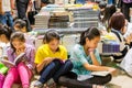 Chinese young school girls sitting on the floor and reading books at the Shenzhen Central Bookstore in Futian district, Shenzhen,