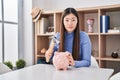 Chinese young woman holding hammer and piggy bank relaxed with serious expression on face Royalty Free Stock Photo