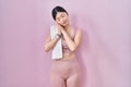Chinese young woman wearing sportswear and towel sleeping tired dreaming and posing with hands together while smiling with closed Royalty Free Stock Photo