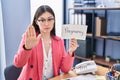 Chinese young woman working at the office holding pregnancy sign with open hand doing stop sign with serious and confident