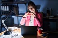 Chinese young woman working at the office at night smiling in love doing heart symbol shape with hands Royalty Free Stock Photo