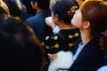 Chinese young women hold pet dogs in crowds watching entertainment