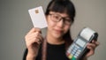 Chip card holding by asian woman in blurry with post terminal or EDC for payment, Concept of contactless card for new way of