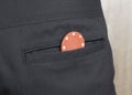 A chip from the casino in the back pocket of the pants, close-up