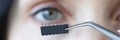 Chip is inserted into womans eye with tweezers closeup