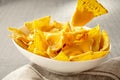 Chip pulled out of bowl of cheese covered nachos