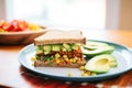 chipotle tempeh sandwich with corn salsa and avocado slices