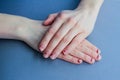 Chipped, stratified nails. nails after gel Polish. untidy hands on a blue background