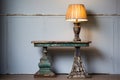 a chippy painted side table with an antique lamp