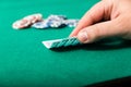 Chips and cards for poker in hand on green table Royalty Free Stock Photo