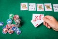 Chips and cards for poker in hand on green table Royalty Free Stock Photo