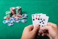 Chips and cards for poker in hand on green table Royalty Free Stock Photo