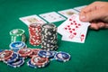 Chips and cards for poker in hand on green table Royalty Free Stock Photo