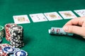 Chips and cards for poker in hand on green table Royalty Free Stock Photo