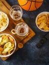 Chips, onion rings, snacks, beer in two glasses and a remote control. Dark blue background. View from above. Watching your Royalty Free Stock Photo