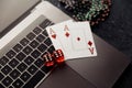 Chips, red dices and playing cards with aces for poker online or casino gambling on laptop keyboard top view. Online Royalty Free Stock Photo