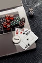 Chips, red dices and playing cards on laptop for poker online or casino gambling close-up. Online casino theme Royalty Free Stock Photo