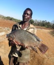 African Fisherman holding a bream