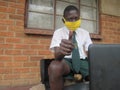 Schoolboy with face mask using laptop at school