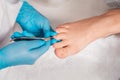 A chiropodist in blue medicine gloves gives a pedicure to the client& x27;s foot, cutting dry skin with clippers. Close Royalty Free Stock Photo