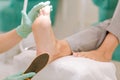 Chiropodist wearing gloves holding feet scrubber in her hand