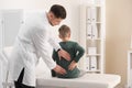 Chiropractor examining child with back pain