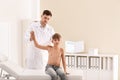 Chiropractor examining child with back pain