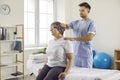 Chiropractor, osteopath or manual therapist massaging senior woman's neck and shoulders