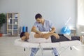 Chiropractor, osteopath, physiotherapist or manual therapist helping patient with backache
