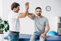 Chiropractor stretching arm of handsome patient on massage table Royalty Free Stock Photo