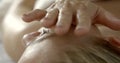 Chiropractor is touching a female head by palm, pressing accupuncture dots