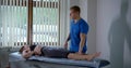 Chiropractor is working with female patient in rehab center,treat musculoskeletal pain