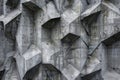 A chiseled concrete wall featuring numerous shelves attached at various angles, Chiseled concrete block with sharp edges and Royalty Free Stock Photo