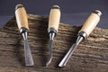 Chisels on a wooden background. Assortment of chisels of wood for carpentry. Set of chisels. A set of tools for wood processing Royalty Free Stock Photo