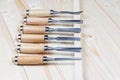 Chisels on a wooden background. Assortment of chisels of wood for carpentry. A set of tools for wood processing Royalty Free Stock Photo