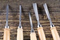 Chisels on a wooden background. Assortment of chisels of wood for carpentry. Set of chisels. A set of tools for wood processing Royalty Free Stock Photo