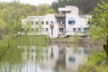 Chisinau, Moldova - April 20 2022 - An abandoned white building in front of a lake in the spring