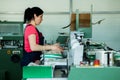 CHISINAU, MOLDOVA - APRIL 26, 2016: Workers in printing house. People working on printing machine in print factory. Industrial wor