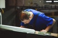 CHISINAU, MOLDOVA - APRIL 26, 2016: Workers in printing house. People working on printing machine in print factory. Industrial wor