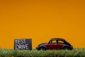 Chisinau, Moldova - August 15th 2019: A car figurine aligned to the right on grass next to a sign which says test drive