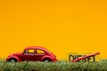 Chisinau, Moldova - August 15th 2019: A red car figurine aligned to the left on grass next to a sign which has the word diesel cut