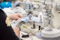 Chisinau, Moldova, March 12, 2019. A young woman who works as a seamstress in purple uniform sews baby clothes on a sewing machine