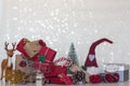 Chistmas background with wrapped gifts, christmas tree, reindeer, pine cone, shopping cart and christmas elf