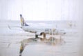 Blurred raindrops on terminal airport`s windows with the SKY airline plan