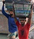 male worker is busy to loading a coal truck on his head . He is working without any safety equipment.