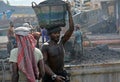 male worker is busy to loading a coal truck on his head . He is working without any safety equipment.