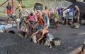 male worker is busy to loading a coal truck on his head . He is working without any safety equipment.