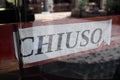 chiuso transl. closed sign in shop window Royalty Free Stock Photo